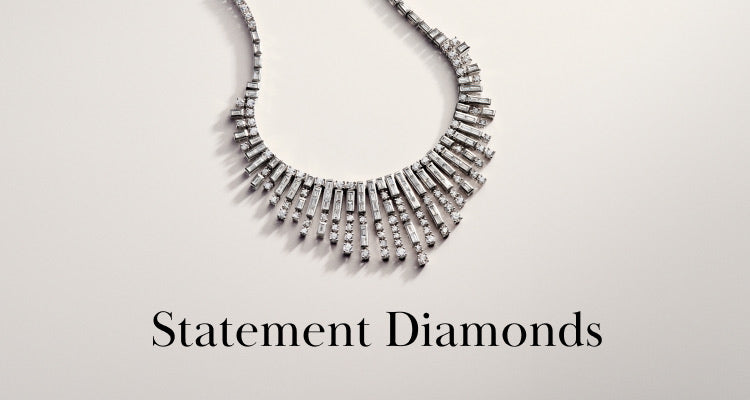 A diamond necklace with an intricate, geometric design is displayed on a light background above the words Statement Diamonds in elegant black font.