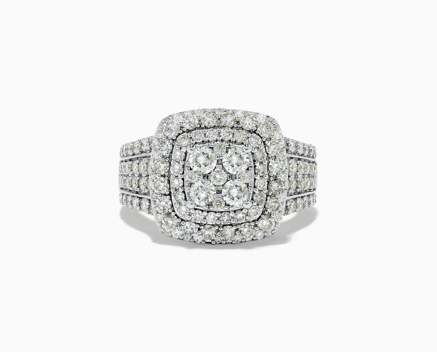 A diamond ring with a cushion-shaped setting, featuring multiple rows of small diamonds around a central cluster of round diamonds, and a triple-band shank also encrusted with diamonds, displayed on a white background.