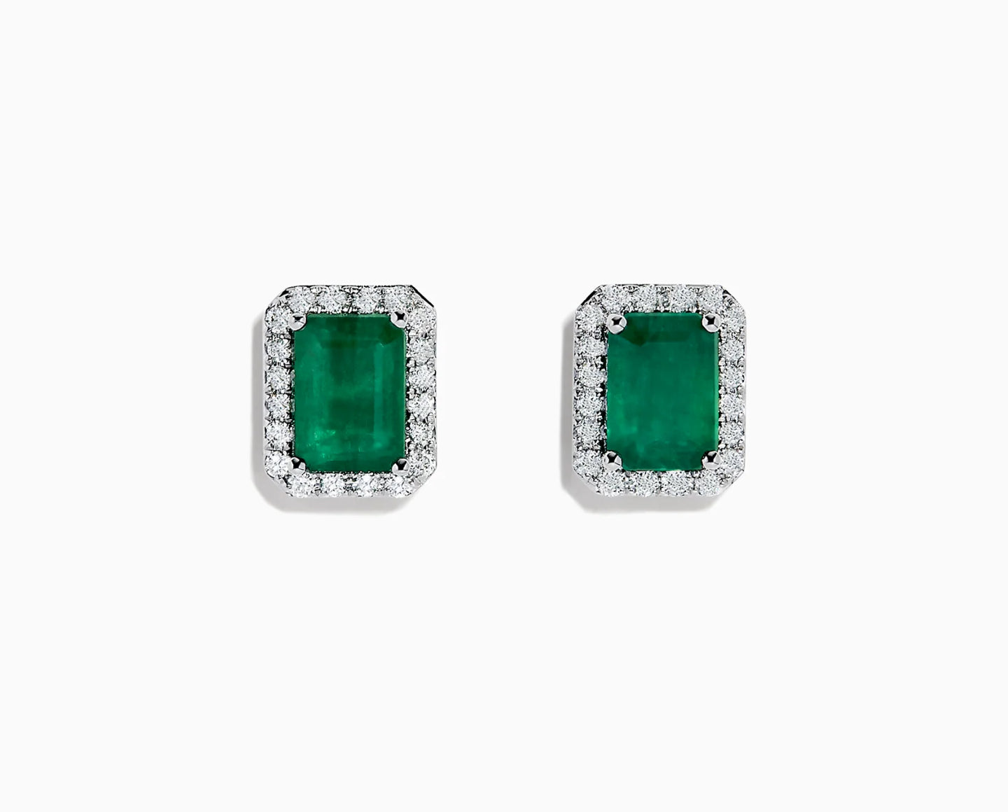 A pair of rectangular emerald stud earrings, each surrounded by a border of small, sparkling white diamonds, set in white metal, displayed on a plain white background.