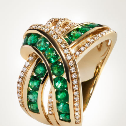 A gold ring with intertwining bands, featuring rows of round green gemstones and small white diamonds set along the curves, creating an elegant and intricate design.